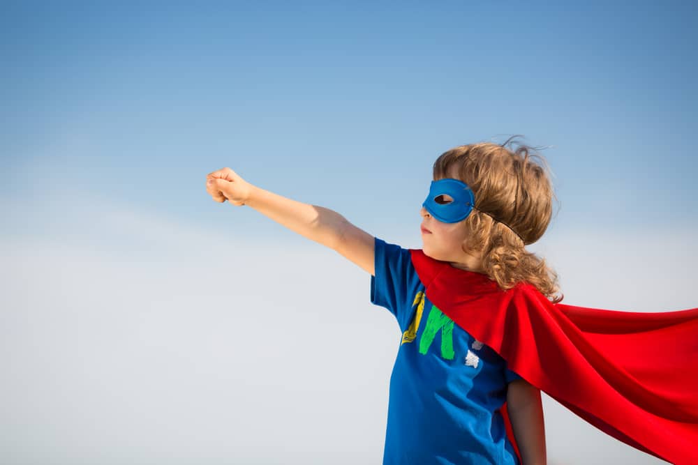 Young boy wearing a red cape