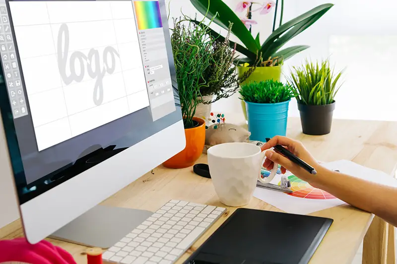 Graphic designer using pen tablet to design a logo.