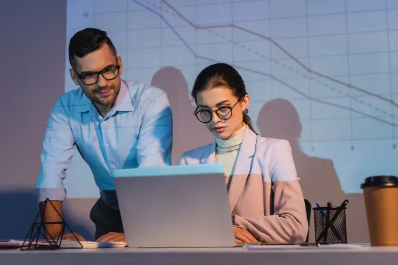 Business people in glasses looking at laptop