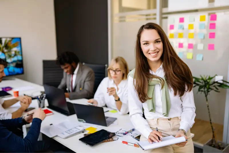 An Employee Sitting on a Table while Smiling