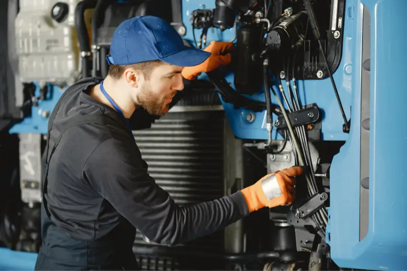 Man in blue cap fixing the machine