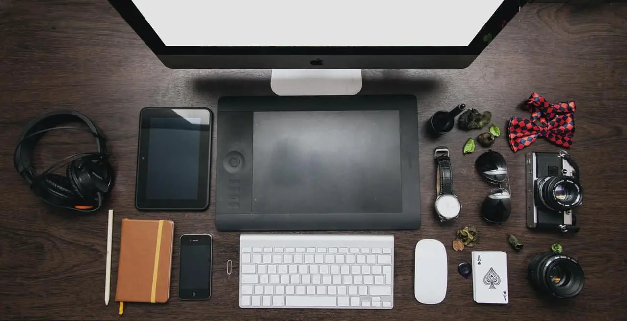 aerial view of desk with laptop, keyboard, mouse and other items