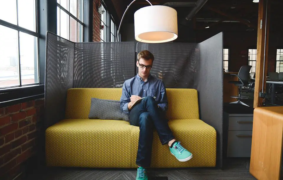 person writing business ideas down in notebook