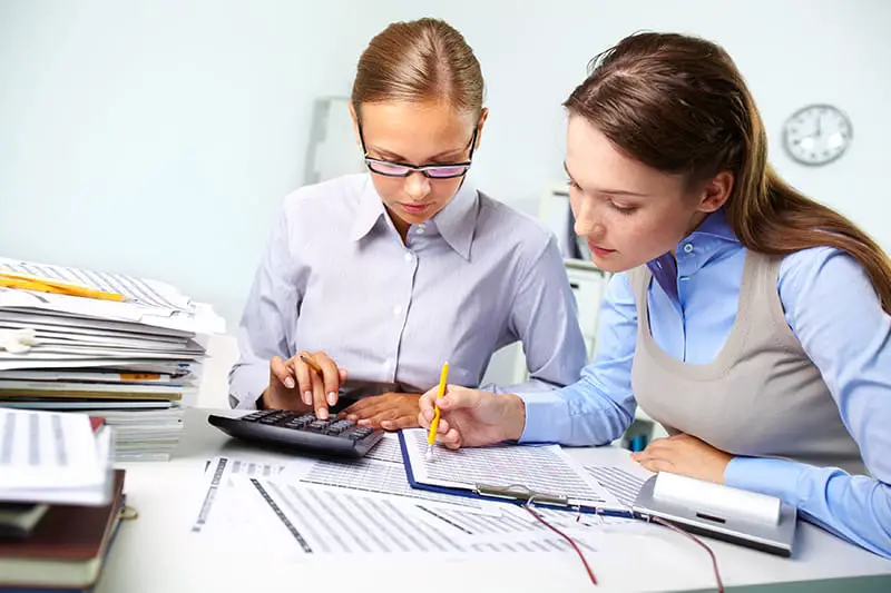 Concentrated business women reviewing accounting report