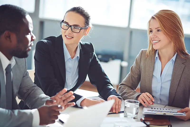 Two businesswomen interviewing young man