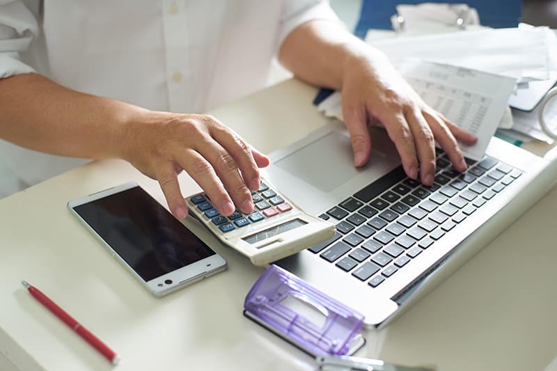 Business men work with calculator and laptop on the white table at office