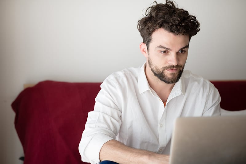 handsome hipster modern man designer working home using laptop at home