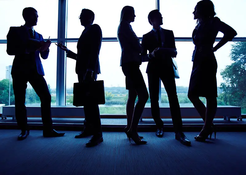 Group of employees having business meeting against window