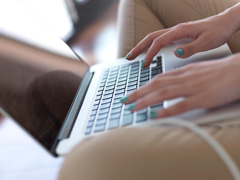 beautiful young woman relax and work on laptop computer modern home office while listening musin on white headphones