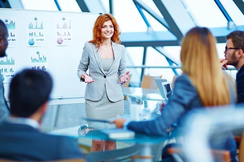 Professionally-trained manager explaining her point of view to colleagues at meeting