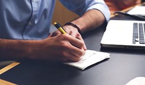 Man writing notes at a desk