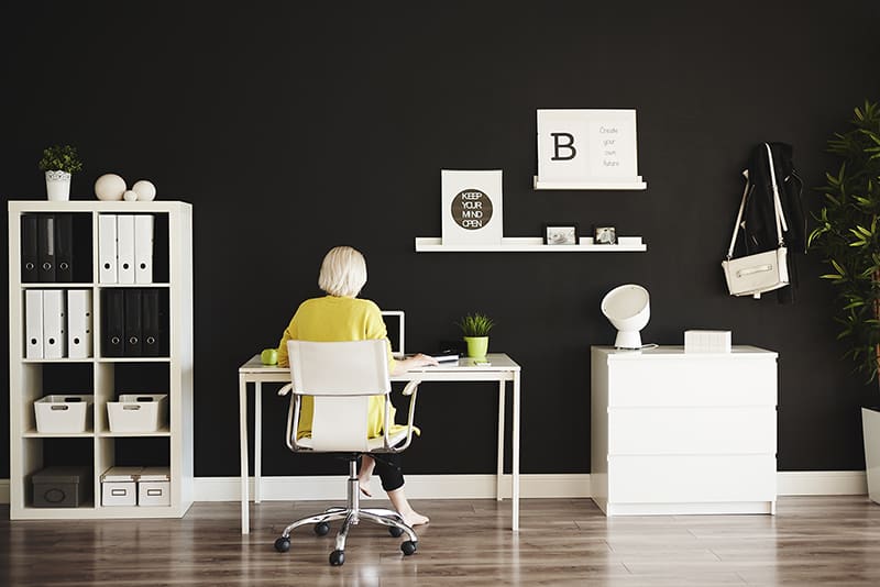 Rear view of businesswoman working at home office - decluttering ideas for your home office