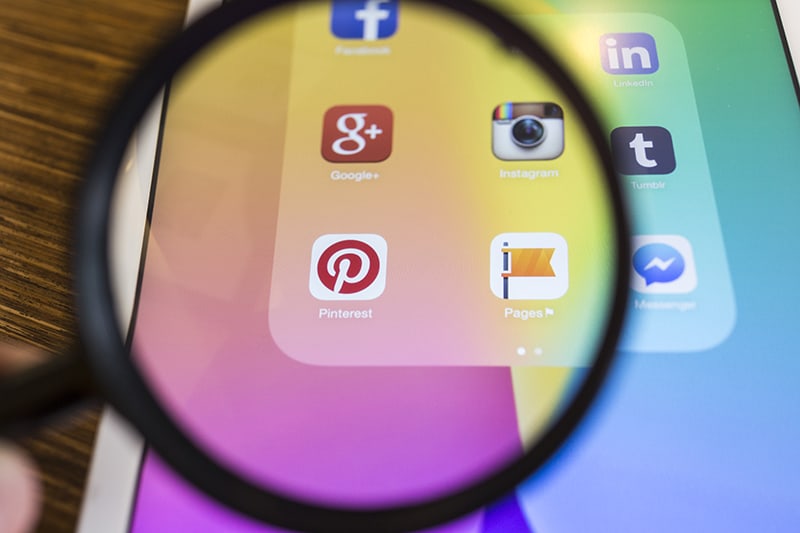 social media icons under magnifying glass  
