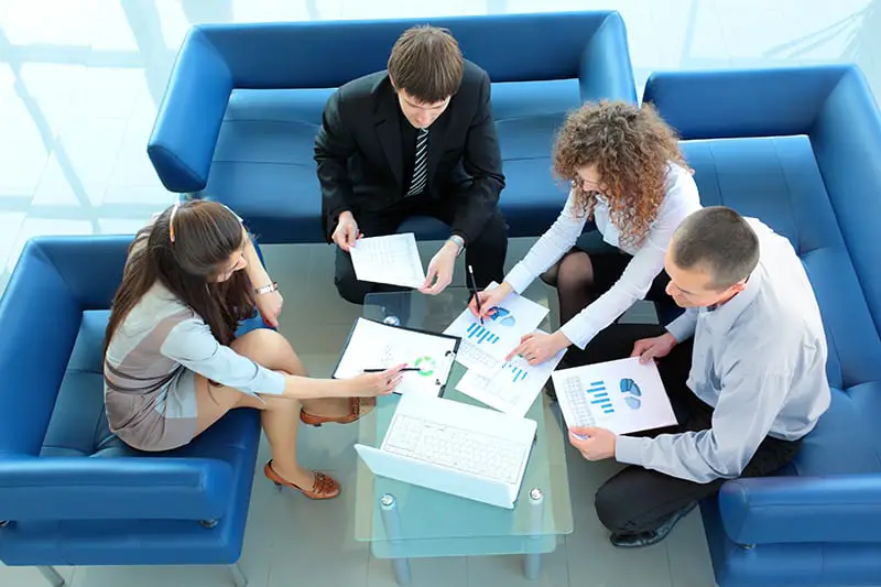 Top view of working business group sitting at table during corporate meeting