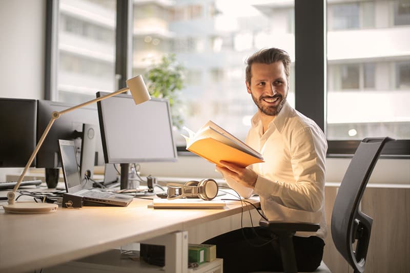 smiling man holding  a book