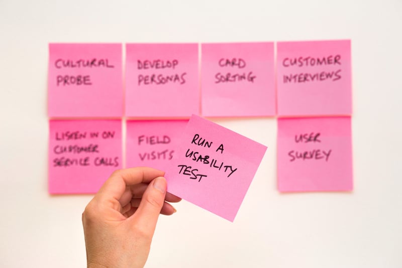 person holding pink post it  sticky note