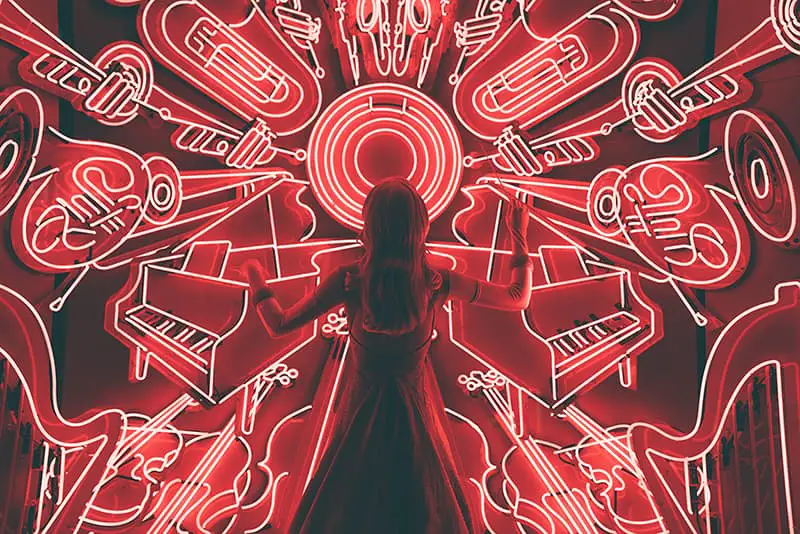 Woman conducting music to neon musical instruments