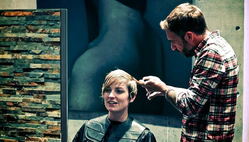 Hairdresser cutting client's hair