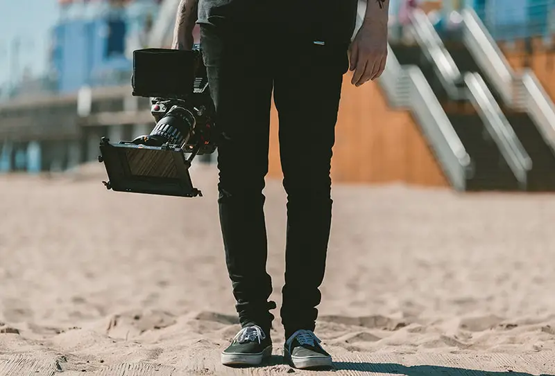 Photographer/videographer holding camera on the beach