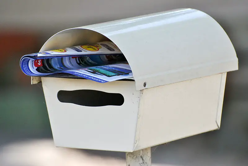 white mail box with leaflet in it