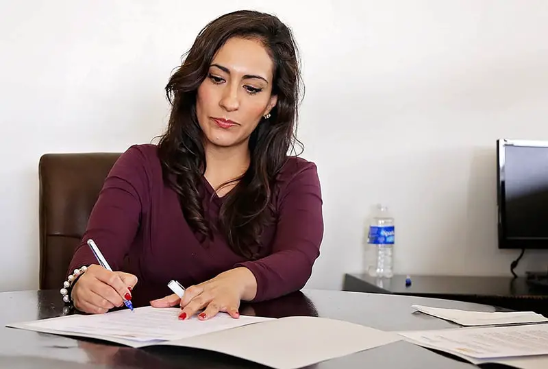 woman working in office signing paperwork