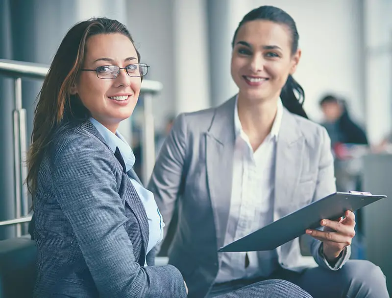 Image of confident businesswoman looking at camera during meeting with co-worker