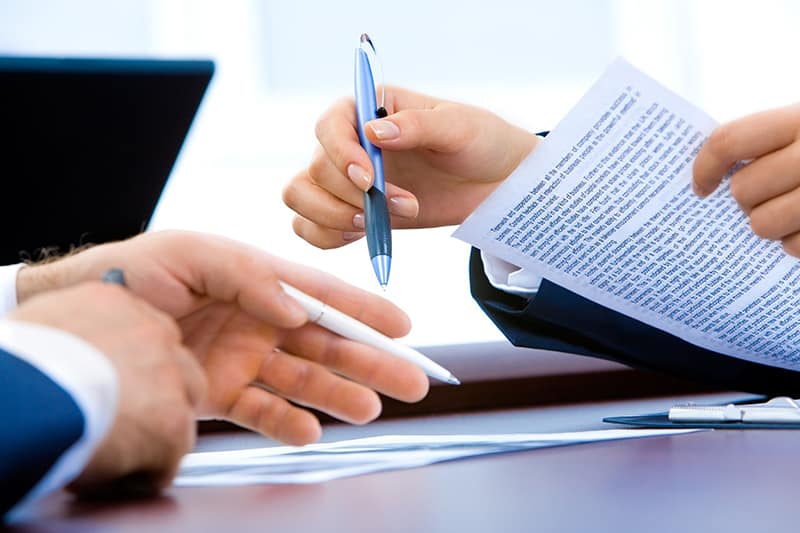surety underwriting - two people looking at documents contracts
