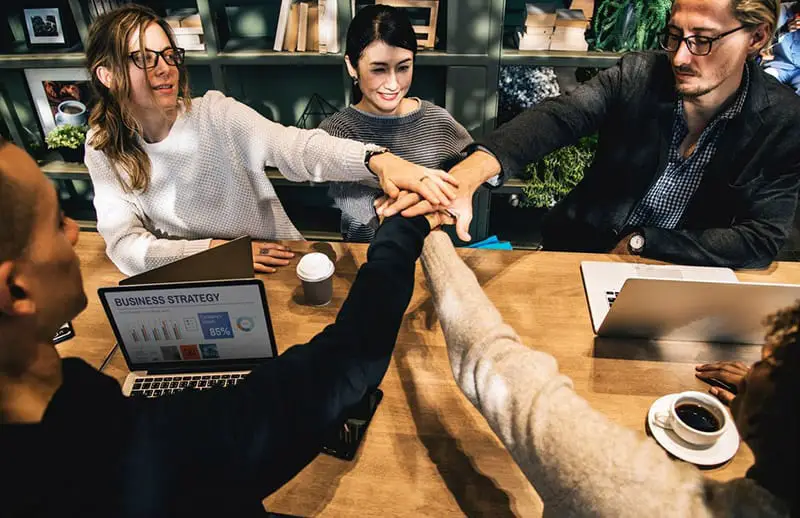 group of people stacking handing showing team work - crisis management planning