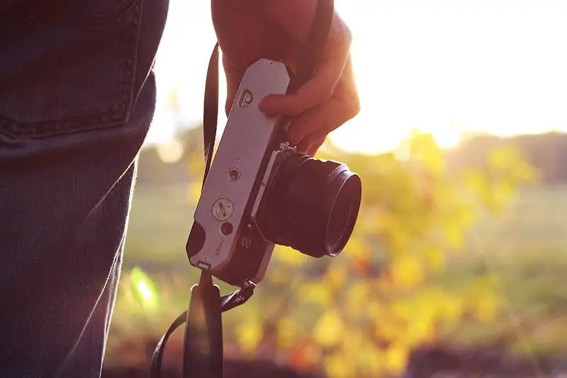 Photography business - person outdoors holding camera down by their side