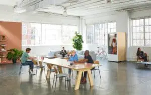 Build a successful startup - people sitting on a chair at a tavle inside large open plan room