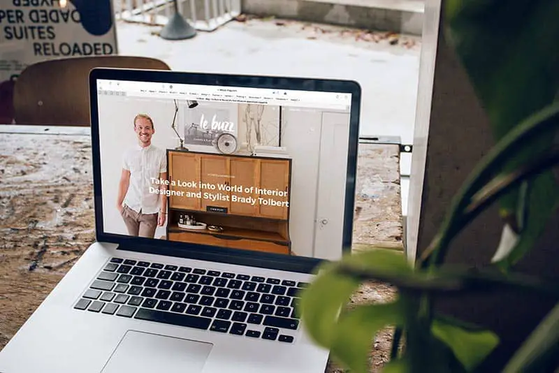 MacBook Pro on top of brown wooden table during daytime showing a website on the screen