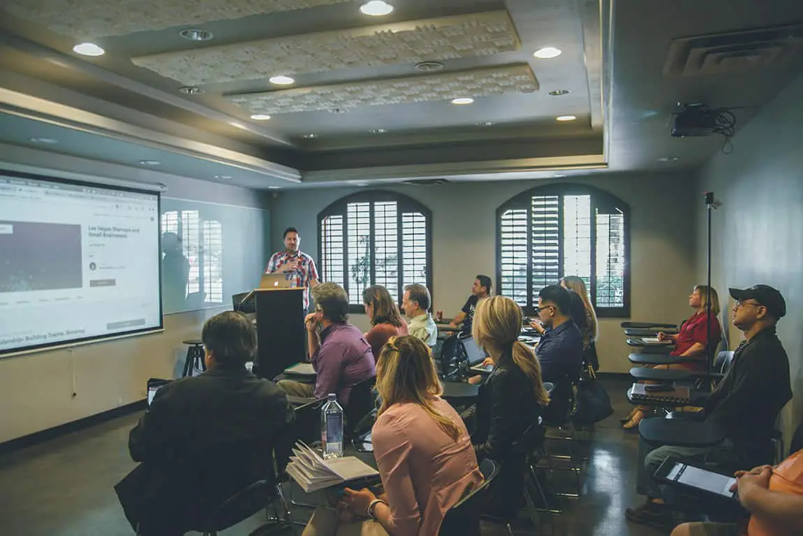 Person standing up in front of audience giving PowerPoint presentation