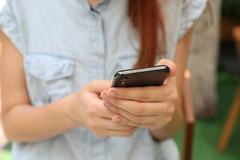 Person holding and looking at apps on smartphone