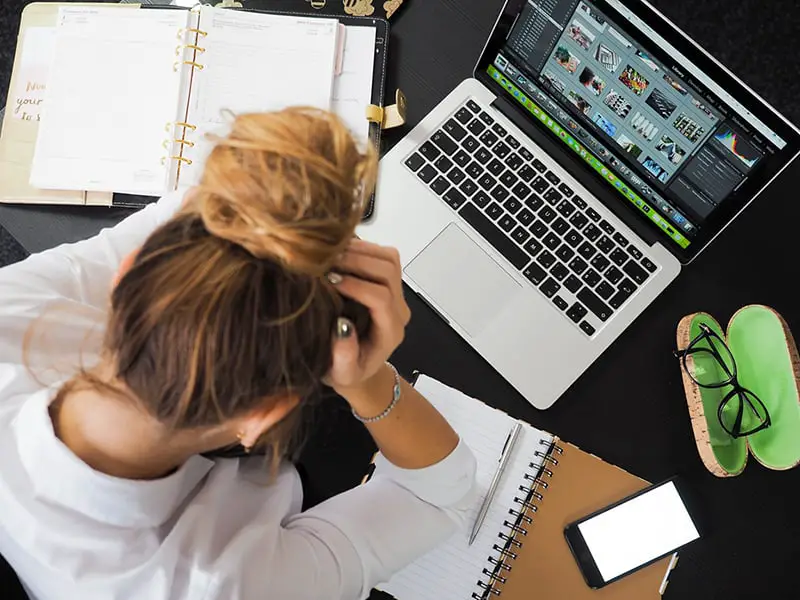 prevent employee burnout - woman at desk with head in hands