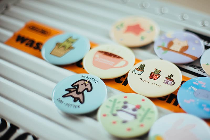 assorted-color custom badges on top of white surface