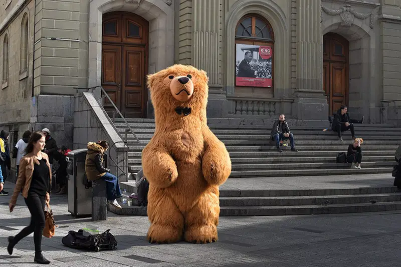 Brown bear mascot standing in front of a building - effective branding