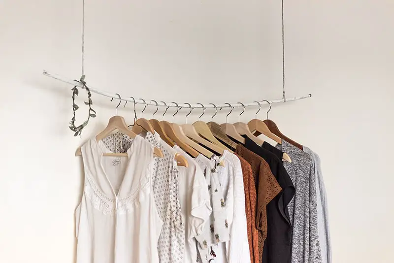Fast fashion - clothes rail with garments hanging from it.