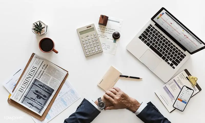 Person sitting at desk looking at watch - time to apply for a hard money loan