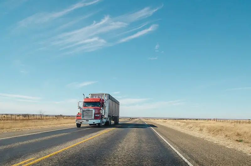 Ared truck driving along a west Texas road
