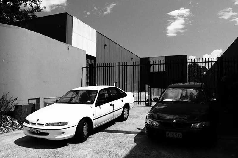 Cars parked next to commercial gating at commercial property