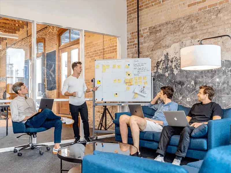 Small business team looking at presentation of field marketing tricks on whiteboard