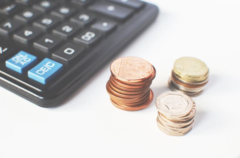 Calculator next to piles of coins