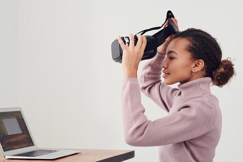 Woman holding black virtual reality goggles - VR headset