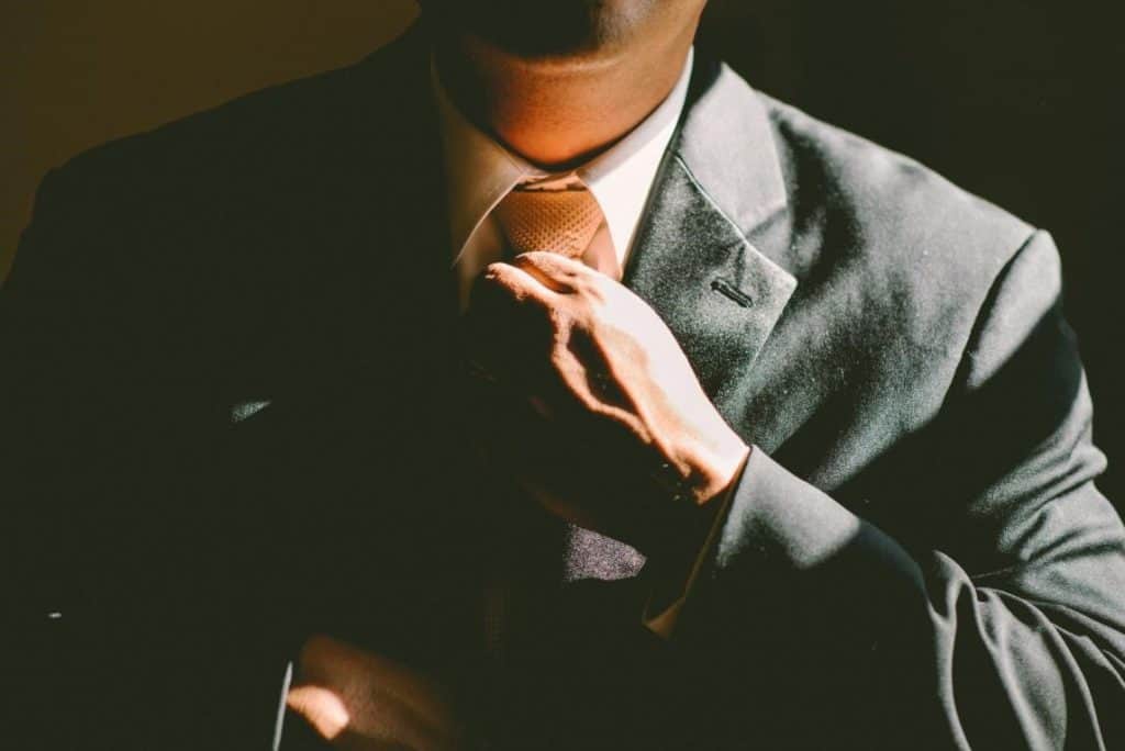 Businessman in suit fixing his neck tie