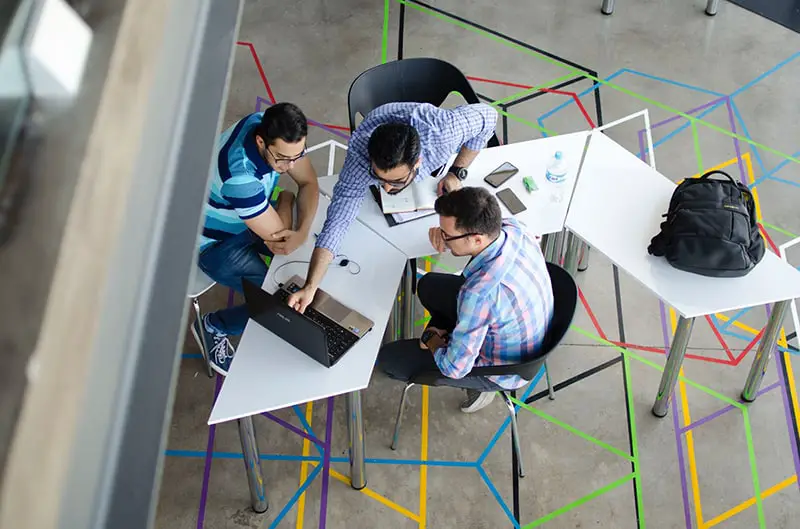 top view of a team of 3 men in front of a laptop – teambuilding new team