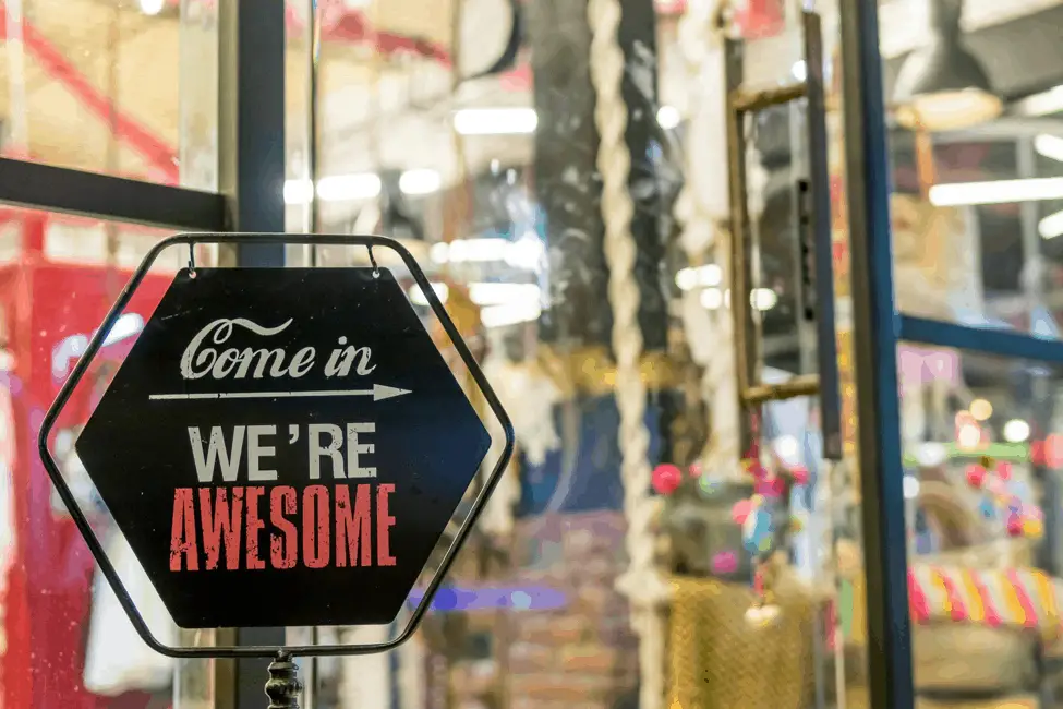 come in we're awesome sign in shop window
