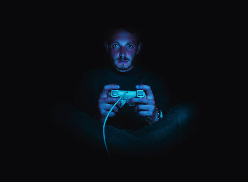 Gamer holding controller playing indie game