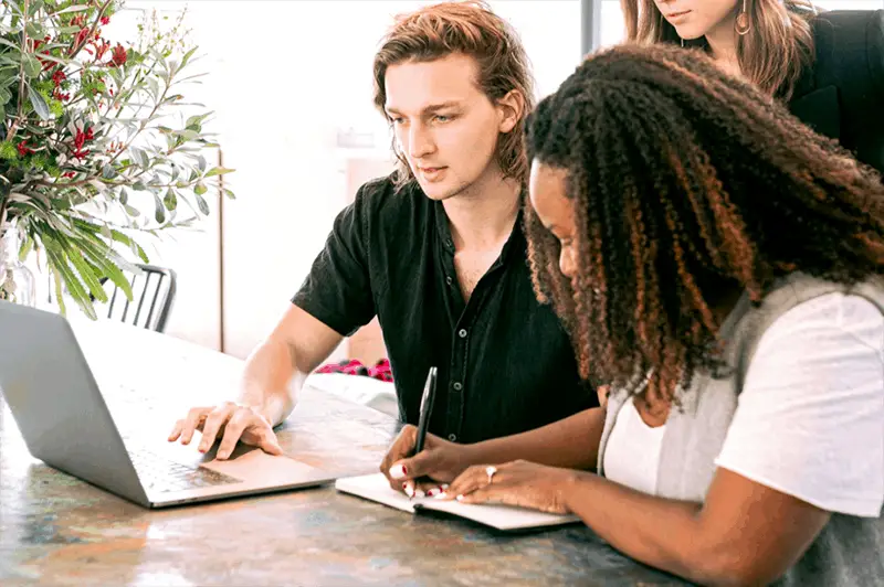 Person using laptop and another making notes for simple ecommerce site