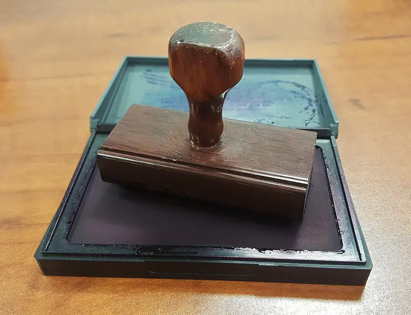 Rubber stamp and ink pad on table