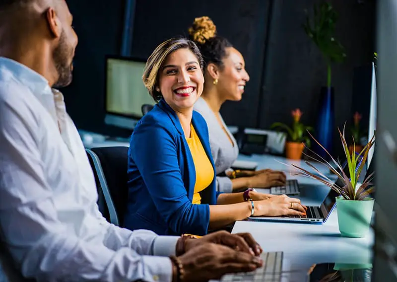 Woman in blue jacket alongside colleagues in a business startup